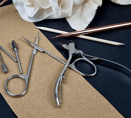 Nail care accessories lying on the surface, including nail scissors, clippers, drills, and nail brush