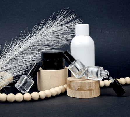 Few different liquid bottles on black surface with wooden decorations around them